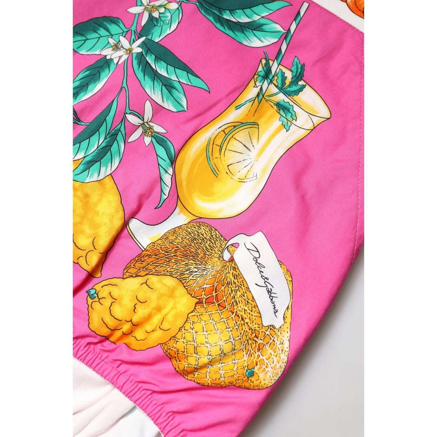 Dolce & Gabbana pink cotton shorts with vibrant fruit print, featuring lemons and a cocktail design, showcasing high craftsmanship.