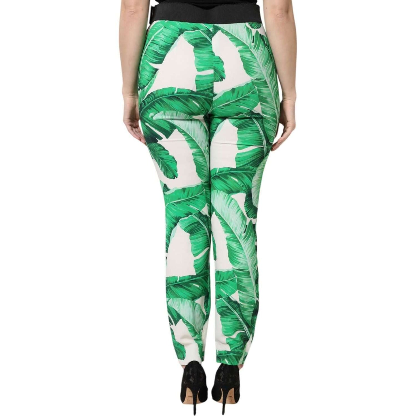 Model wearing Dolce & Gabbana white green leaf print high waist pants, showcasing back view and rich design detail.