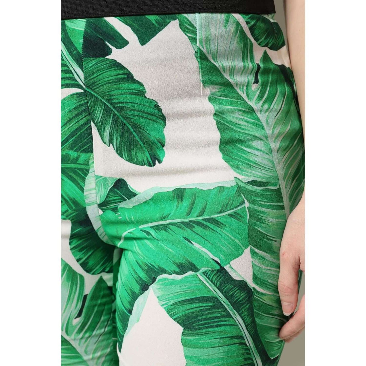 Dolce & Gabbana white high waist pants with green leaf print, featuring regular fit and zipper closure. Made of 100% viscose.