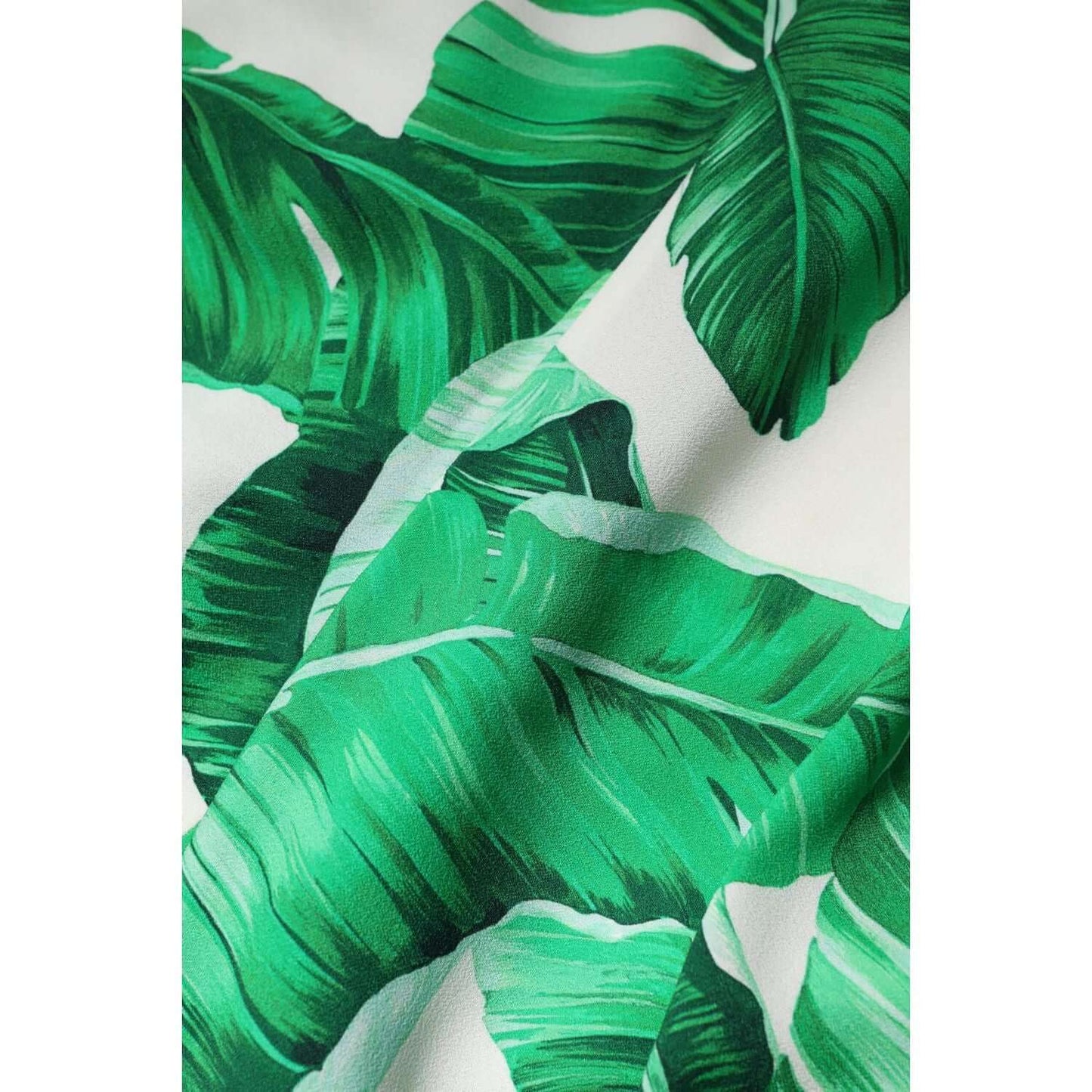 Dolce & Gabbana high waist pants fabric with green leaf print on white viscose material.
