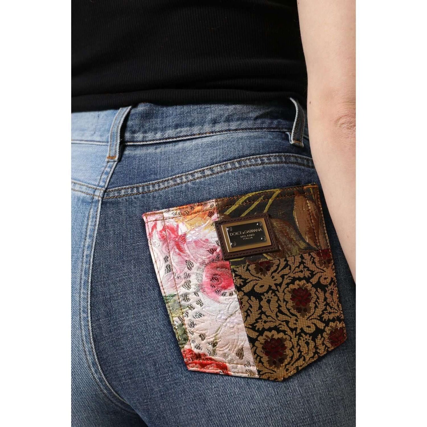 Close-up of Dolce & Gabbana multicolor patchwork pocket on high waist denim jeans, featuring floral jacquard and logo detail.