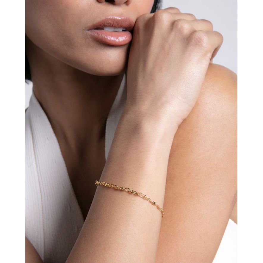 Elegant lady wearing a gold bracelet, showcasing the sleek design and chic style of the jewelry accessory.