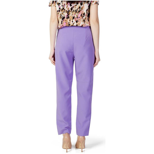Woman wearing only purple polyester cigarette pants from spring/summer collection, featuring recycled polyester and elastane.