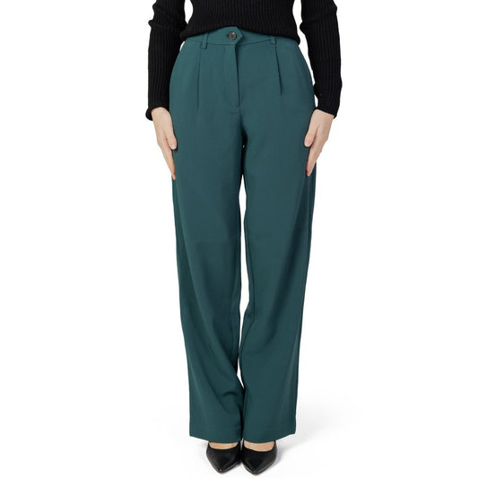 Woman wearing green bootcut pants made of recycled polyester for autumn winter collection, eco-friendly fashion