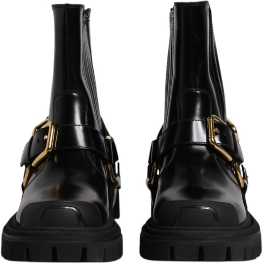 Dolce & Gabbana black leather mid calf slip on trekking boots with gold metal detailing and rubber sole, view of front design