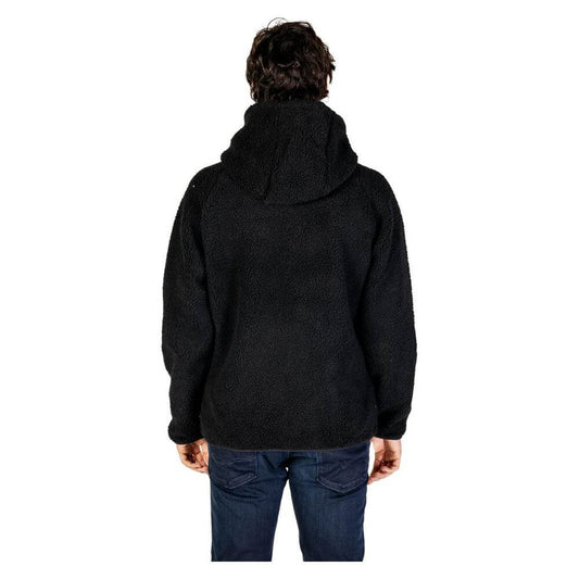 Back view of a man wearing a Hydra Clothing black polyester jacket from the men's fall/winter collection.