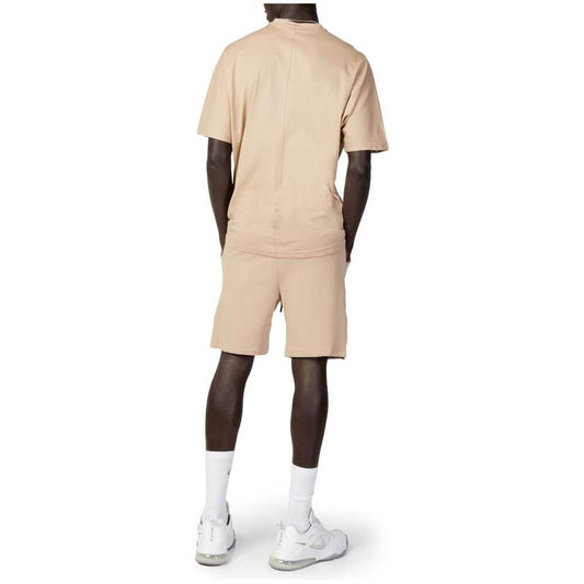 Back view of a man wearing a beige Hydra Clothing cotton sweatsuit, part of the men's short suit spring/summer collection.