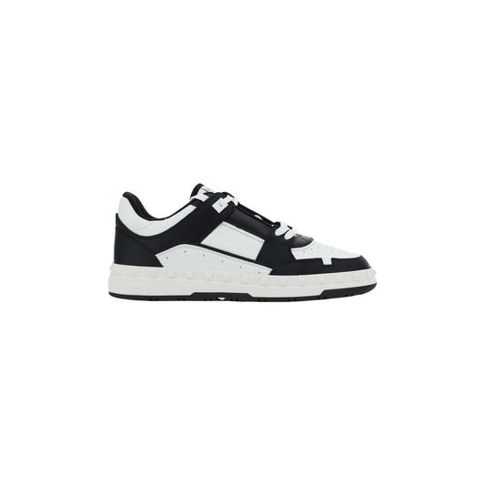 Valentino Garavani leather sneakers with lace closure, flat sole, conical studs on heel, round toe, contrast stitching, and logo label.