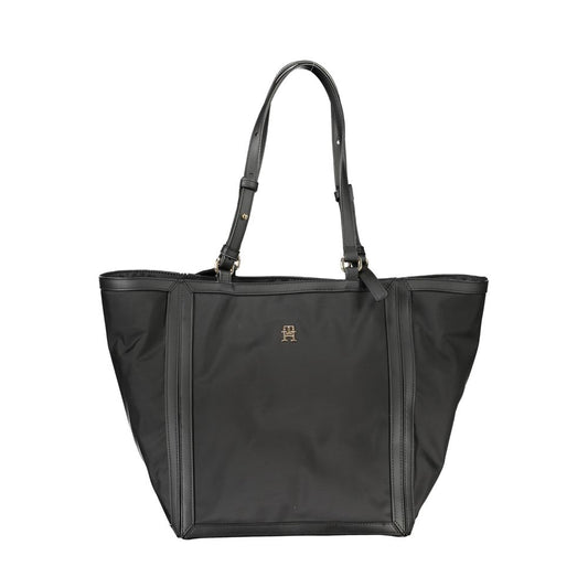 Tommy Hilfiger black polyester handbag with adjustable shoulder handles, zip closure, contrasting details, and logo.