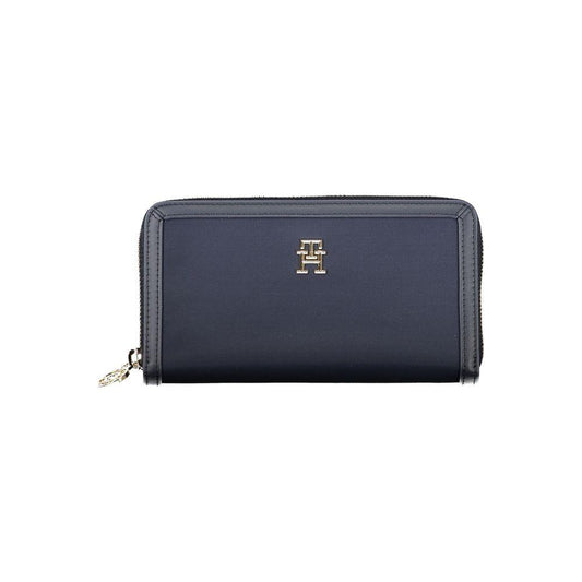 Tommy Hilfiger blue wallet with zip closure, featuring logo, made from recycled polyester, with multiple compartments for cards and coins.
