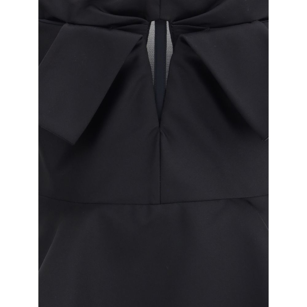 Close-up of Alexander McQueen Black Polyester Top showing bow detail and peplum design, highlighting elegant style and fit.