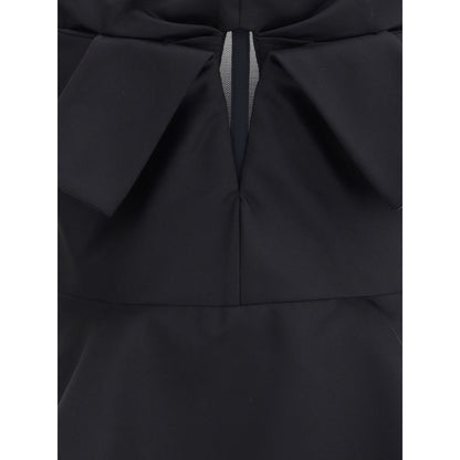 Close-up of Alexander McQueen Black Polyester Top showing bow detail and peplum design, highlighting elegant style and fit.