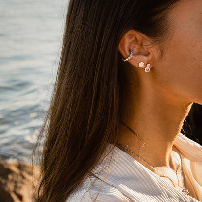 Side profile of a woman wearing AN JEWELS JEWELRY Mod. AL.NLFY01 earrings by the ocean.