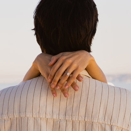 Close-up of a woman embracing a person, showing a ring on her finger.
