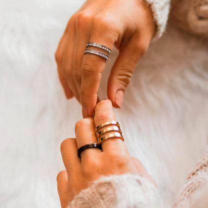 Hands wearing AN JEWELS JEWELRY Mod. AR.R3NS02Y-8 rings on soft white background