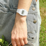 Person wearing CASIO VINTAGE Mod. F-91 BIO RESIN STRAP - WHITE watch outdoors, highlighting its unisex design and multifunction capabilities.