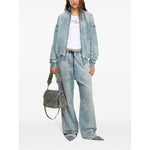 Model wearing Diesel Top White and denim jacket with matching pants, holding a designer handbag, showcasing casual fashion style.