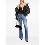 Model wearing Diesel Underwear Black bodysuit with adjustable straps, denim jeans, and black jacket.