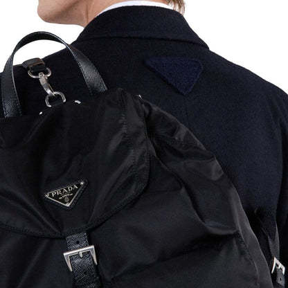 Back view of a Prada Blue Wool Coat with back triangle logo detail and backpack, highlighting the men's fashion design.