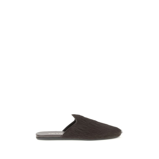 Prada Leather Mules with long hair and metal logo, tapered silhouette. Elegant footwear for AW25 season.