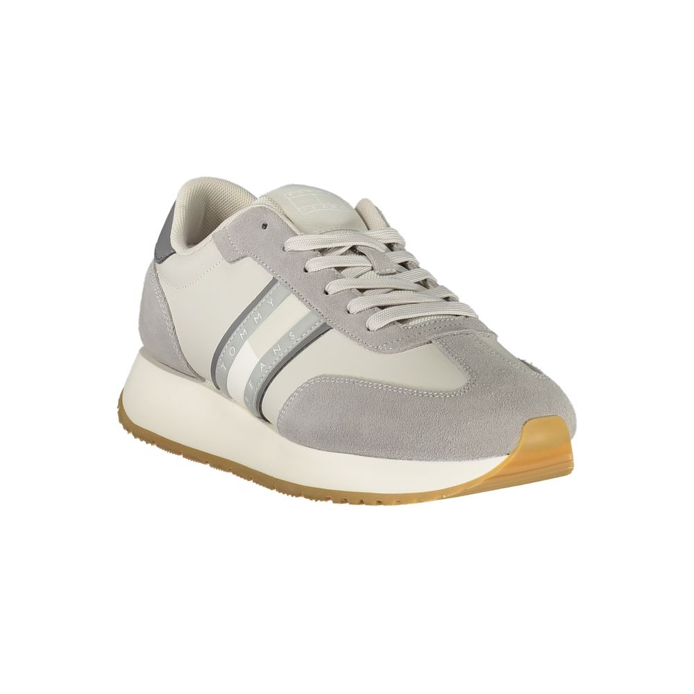 Modern grey and white sneaker with suede texture and gum sole, showcasing side stripes and lace-up design for casual wear.