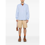 Model wearing Valentino Formal Shirt with button-down collar and VLogo Signature, paired with beige shorts and brown shoes.