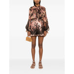 Model wearing Zimmermann Illuminate Flutter Shorts with floral print and ruffled trim, styled with a matching top and sandals.