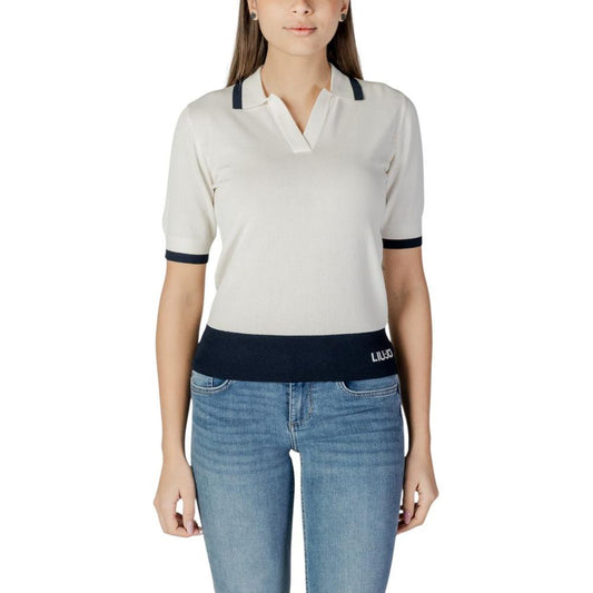 Woman wearing Liu Jo white viscose top with black accents, part of the spring/summer collection, paired with blue jeans.